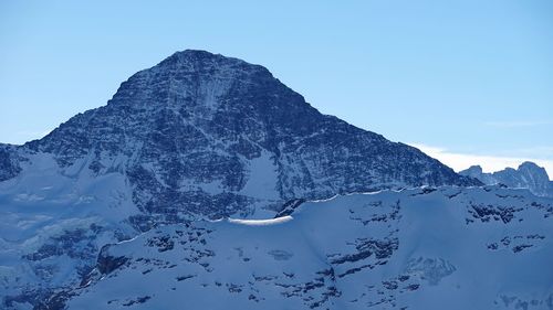 Scenic view of snowcapped mountains against clear sky