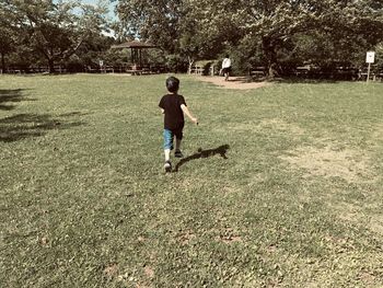 Rear view of man walking on field