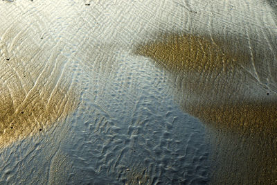 Full frame shot of wet glass on beach