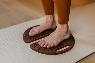 Low section of person standing on hardwood floor