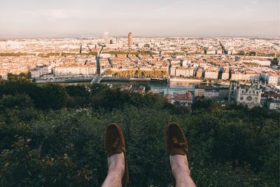 Low section of man with cityscape in background