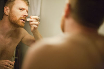 Portrait of shirtless man in bathroom