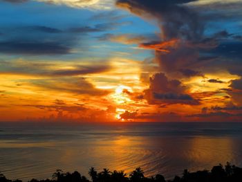 Scenic view of sea against dramatic sky during sunset