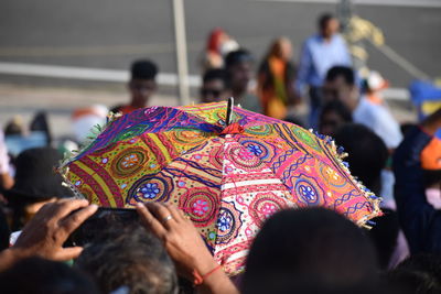 People around multi colored umbrella in city