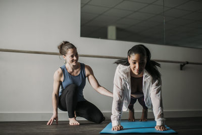 Personal trainer coaches her african american client do a push up