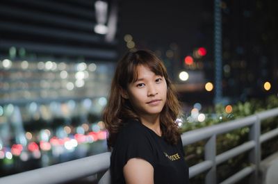 Portrait of woman standing in city at night