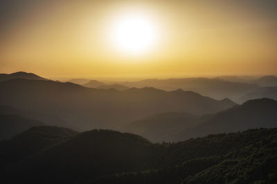 Scenic view of silhouette mountains against sky during sunset