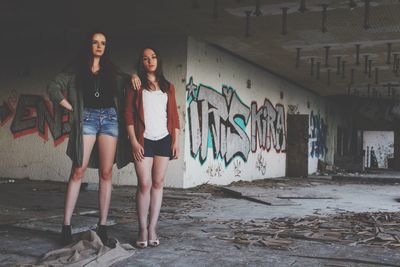 Full length of woman standing against wall