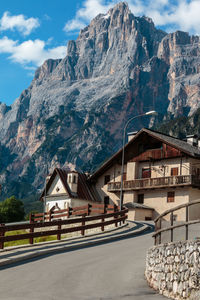 Houses on mountain against cloudy sky