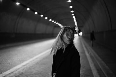 Portrait of woman standing against illuminated lights