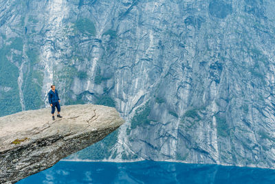 Man standing on cliff over lake