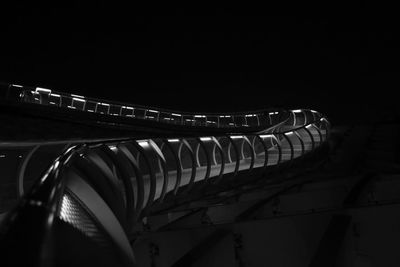 Low angle view of illuminated bridge against sky at night