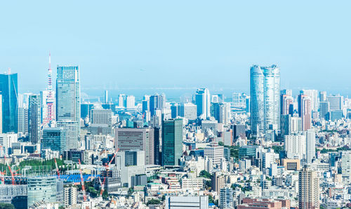 Modern buildings in city against blue sky