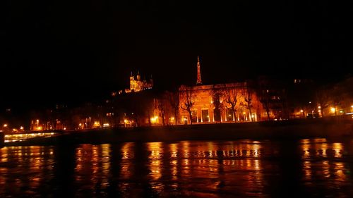 Reflection of illuminated building in water at night