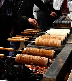 Midsection of men preparing food on barbecue grill