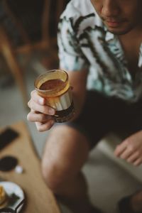 Midsection of man holding coffee cup