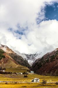 Scenic view of field and mountains against sky