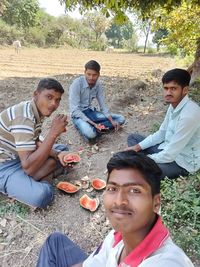 Portrait of friends sitting on land