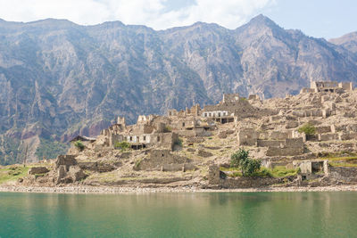 Panoramic view of lake and buildings against mountains