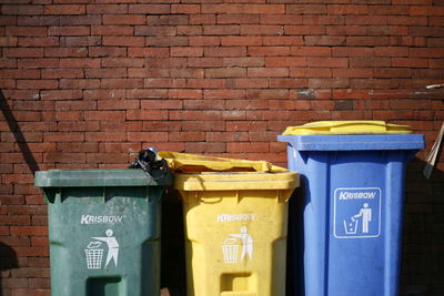 Garbage bin against brick wall