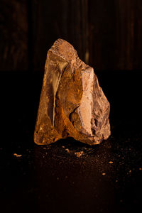 Close-up of stone on rock against black background