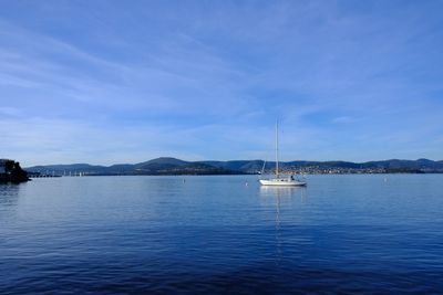 Sailboat sailing on lake against sky