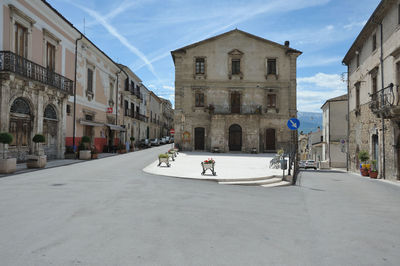 Street amidst buildings in city against sky