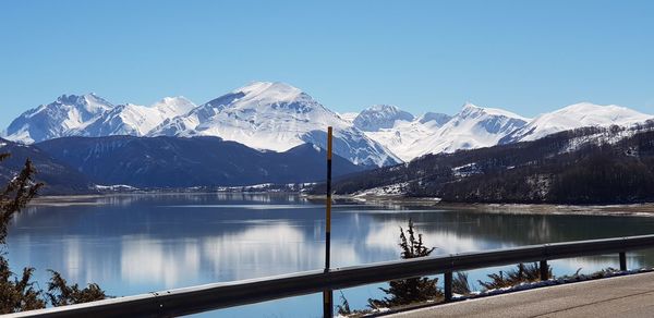 Scenic view of snowcapped mountains against clear blue sky