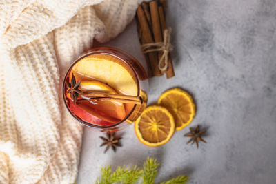 A glass of hot christmas mulled wine with spices and fresh fruit pieces. traditional winter drink