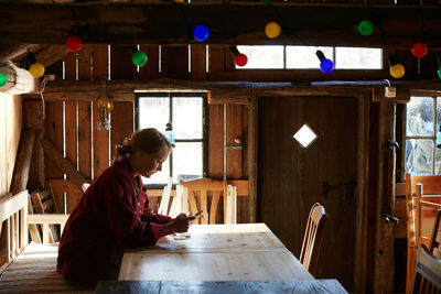 Side view of woman sitting on table