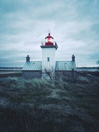 Lighthouse by sea against sky
