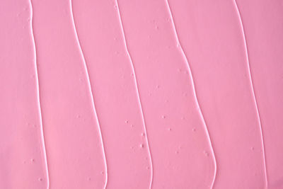 The texture of the cosmetic gel on a pink background.