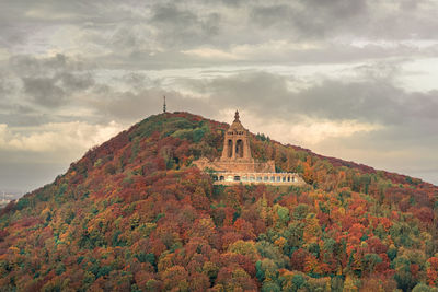 View of cross on mountain against cloudy sky