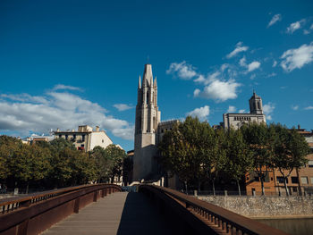 Bridge over canal amidst buildings in city against sky