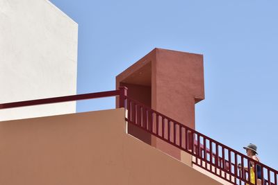 Low angle view of staircase by building against clear blue sky