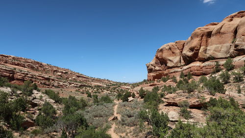 Low angle view of rocky mountains against clear blue sky