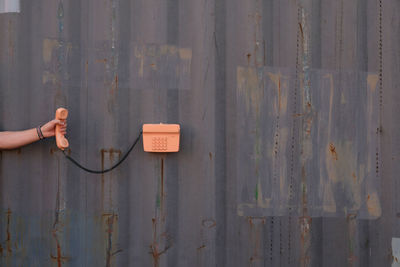 Midsection of person holding text on wall