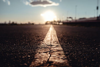 Surface level of road against sky during sunset