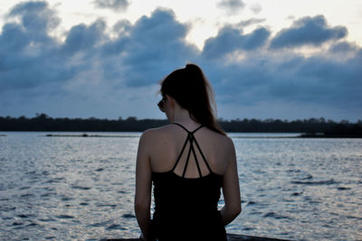 Rear view of woman looking at sea against sky