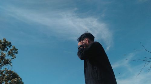 Low angle view of man standing against sky