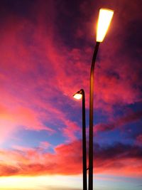 Low angle view of illuminated street light against sky