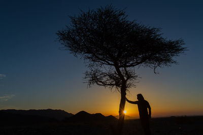 Silhouette woman standing against clear sky