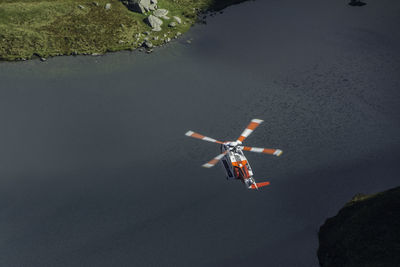 High angle view of helicopter flying over rocks