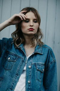 Thoughtful woman wearing denim jacket while standing outdoors