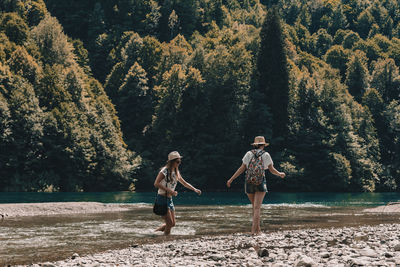 Full length of people at lake against trees