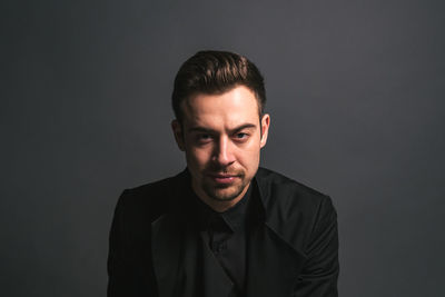 Portrait of young man against black background