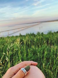 Cropped hand of woman against sky