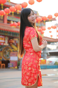 Side view of a smiling young woman standing outdoors