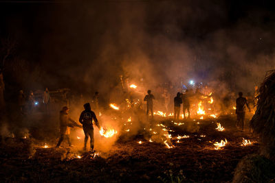 Group of people against fire at night