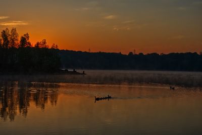 Scenic view of lake against orange sky